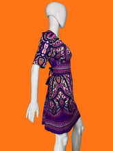 Load image into Gallery viewer, A side view of a purple and pink paisley print short-sleeve dress displayed on a white mannequin.