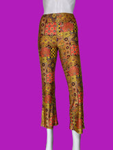 Load image into Gallery viewer, Patchwork print flare pants in a multicolor mix of orange, yellow, red, and black geometric and floral patterns, displayed on a white mannequin.