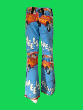 Load image into Gallery viewer, Blue wide-leg pants with a cartoon car print and white text, displayed on a mannequin stand against a white wall.