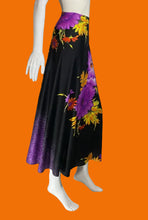 Load image into Gallery viewer, A black midi skirt with a purple and yellow floral print and a purple ombre hem, displayed on a white mannequin.