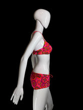 Load image into Gallery viewer, A two-piece bikini swimsuit with a vibrant pink, red, and green paisley pattern, displayed on a white mannequin.