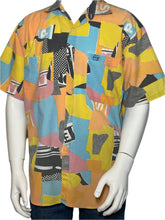 Load image into Gallery viewer, Mannequin wearing a colorful geometric-patterned shirt on a plain background