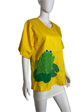 Load image into Gallery viewer, Yellow t-shirt with a green frog design on a mannequin against a white background