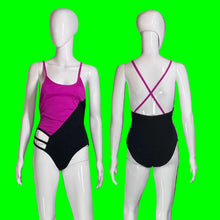 Load image into Gallery viewer, A one-piece swimsuit shown on two white mannequins against a black background, displaying the front and back views. The swimsuit features a bright magenta pink and black color-blocked design with magenta crisscross back straps.
