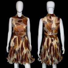 Load image into Gallery viewer, A sleeveless fit-and-flare dress displayed on a white mannequin, shown from both front and back. The dress features a brown and beige abstract leaf print on a sheer mesh fabric, with a matching waist sash and bow detail on the front.

