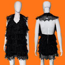 Load image into Gallery viewer, Black ruffled tulle dress shown on a white mannequin from the front and back, featuring a tiered ruffle skirt and a sheer ruffled collar.
