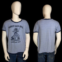 Load image into Gallery viewer, A heather blue ringer t-shirt with dark navy trim, shown from both front and back on a white mannequin. The front features a navy graphic of a man with guitar pedals for feet and the text "MORLEY MEN DO IT...with their feet"
