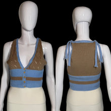 Load image into Gallery viewer, A cropped knit top shown on two white mannequins, front and back views, in light blue and brown. The top features a V-neck on the front with a button closure and an open-knit pattern, and tie straps on the back.
