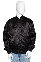 Load image into Gallery viewer, Black satin bomber jacket on a mannequin with light blue jeans against a white background
