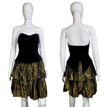 Load image into Gallery viewer, Black strapless dress with a gold tiered skirt on a mannequin against a plain background
