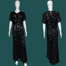 Load image into Gallery viewer, A black floral print silk burn out maxi dress displayed on a white mannequin, showing both front and back views.
