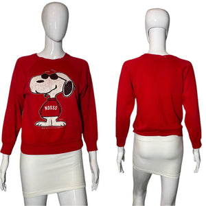 Red sweatshirt with a dog graphic on a mannequin against a plain background