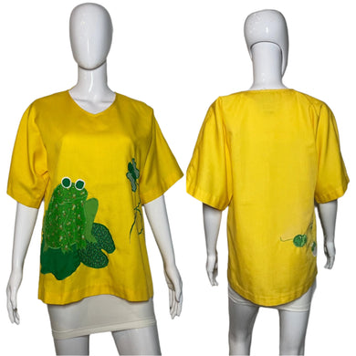 Yellow t-shirt with green frog design on a mannequin against a plain background