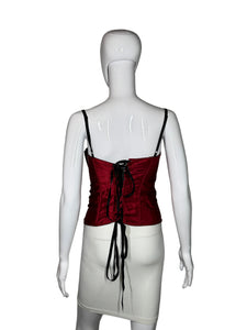 White mannequin wearing a red corset with black laces on a gray background