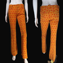 Load image into Gallery viewer, Orange and yellow geometric patterned flare pants displayed on a white mannequin with a black background.
