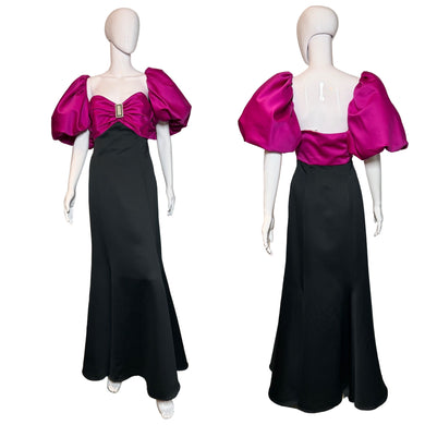 Pink and black dress on a mannequin against a plain background