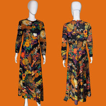 Load image into Gallery viewer, A long-sleeve maxi dress with a vibrant multicolor floral and abstract print on a black background, shown from both the front and back on white mannequins.
