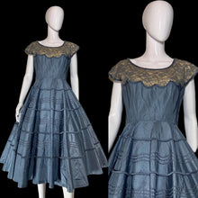 Load image into Gallery viewer, A blue tiered taffeta dress with a lace shoulder detail, displayed on a white mannequin.
