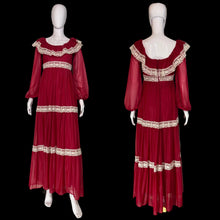 Load image into Gallery viewer, A long maroon chiffon and lace prairie dress displayed on a white mannequin from the front and back, featuring sheer long sleeves, a square neckline with cream lace trim, and matching lace bands at the waist and hem.
