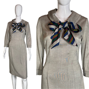 Mannequin wearing a beige dress with a colorful scarf against a plain background