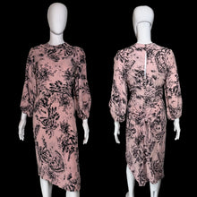 Load image into Gallery viewer, A pink long-sleeve dress with a black floral print, shown from both the front and back on white mannequins.
