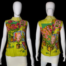 Load image into Gallery viewer, A sleeveless blouse shown on a white mannequin from both front and back views. The blouse features a vibrant retro floral and botanical print with a lime green base, pink flowers, and yellow-green leaves.
