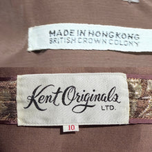 Load image into Gallery viewer, Close-up of a garment's interior labels, featuring a prominent 'Kent Originals LTD.' label and a smaller 'MADE IN HONGKONG BRITISH CROWN COLONY' label stitched onto brown fabric.
