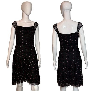 Black polka dot dress on a mannequin against a plain background