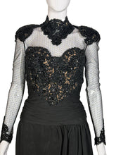 Load image into Gallery viewer, Black dress with sheer sleeves and embellishments on a mannequin against a neutral background
