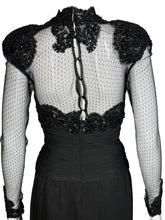Load image into Gallery viewer, Black dress with sheer sleeves and embellishments on a mannequin against a neutral background
