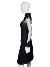 Load image into Gallery viewer, Black dress with sheer sleeves and embellishments on a mannequin against a neutral background
