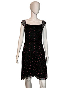 Black polka dot dress on a mannequin against a plain background