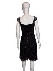 Black polka dot dress on a white mannequin against a plain background