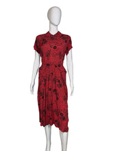 Load image into Gallery viewer, Red dress with black floral pattern on a mannequin against a white wall.
