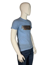 Load image into Gallery viewer, Blue t-shirt with graphic design on a mannequin against a plain background
