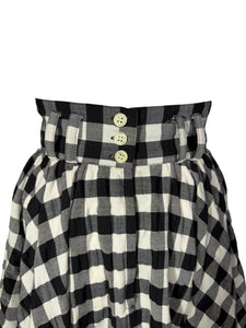 Black and white checkered skirt with button details on a plain background