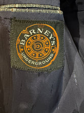 Load image into Gallery viewer, Close-up of a label with 'Barney's Underground' branding on a dark fabric background.

