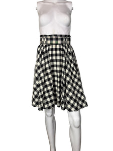 Mannequin wearing a black and white checkered skirt against a plain background