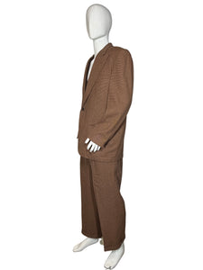 Brown pants on a mannequin against a white wall.