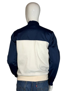 Mannequin wearing a navy and white jacket with blue jeans on a plain background