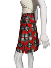 Load image into Gallery viewer, Mannequin wearing a white top and red patterned skort on a plain background.
