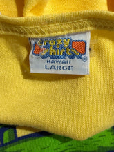 Load image into Gallery viewer, Close-up of a yellow fabric with a label on a multicolored background
