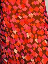 Load image into Gallery viewer, Patterned fabric with red and pink geometric design on a brown background
