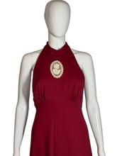 Load image into Gallery viewer, Red dress with a white emblem on a white mannequin against a white background

