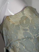 Load image into Gallery viewer, Floral patterned fabric on a white surface with armpit staining
