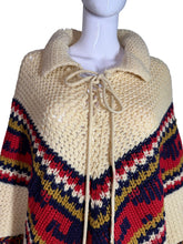 Load image into Gallery viewer, Knitted poncho with a colorful pattern on a mannequin head against a gray background
