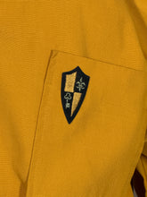 Load image into Gallery viewer, Close-up of a yellow garment with an embroidered logo on a pocket.
