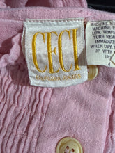 Load image into Gallery viewer, Close-up of a pink fabric with a label and button, featuring the brand 'Ceci'.
