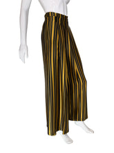Load image into Gallery viewer, Black and yellow striped pants on mannequins with a neutral background
