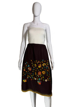 Load image into Gallery viewer, Mannequin wearing a white top and brown skirt with floral embroidery against a plain wall.
